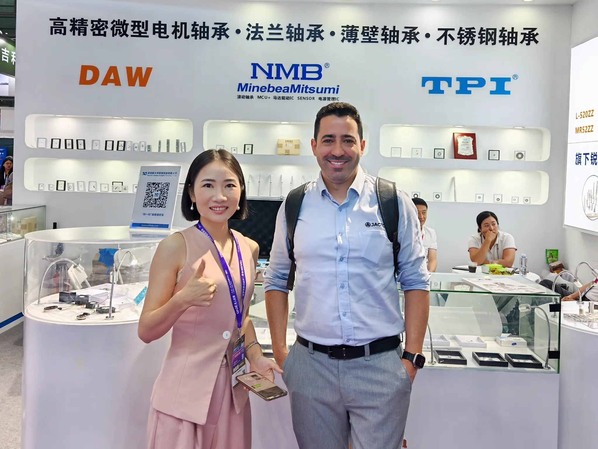 LUMI Bearing representative meeting a customer in front of the bearing product display